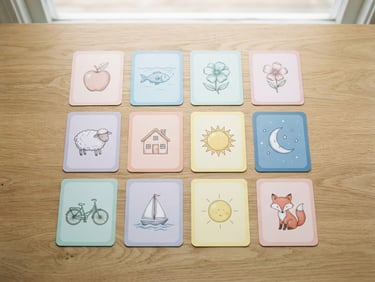 Overhead flat-lay of printed educational cards with soft pastel borders on a clean wooden table, diffused natural daylight, minimalist composition, shallow depth of field.