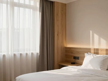 Cozy modern hotel room interior, soft natural light, clean lines, minimalist design with warm wood accents.