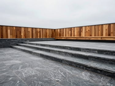 Wide-angle architectural shot of modern paving stone patio and stairs leading down a terraced yard, soft overcast daylight