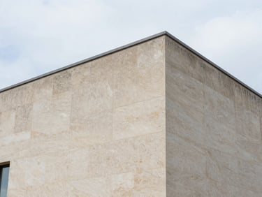 Après : Même façade en pierre de taille après traitement hydrofuge, pierre beige propre et sèche, texture minérale préservée