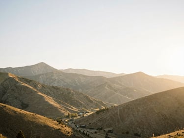 Expansive natural Utah mountain landscape at dawn, soft golden-hour backlighting, peaceful setting