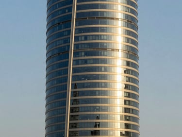 Architectural shot of the United Tower in Manama, bright daylight, high-contrast architectural shadows.