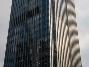 Abstract architectural angles of a modern financial district skyscraper, overcast daylight, sharp shadows, 35mm lens