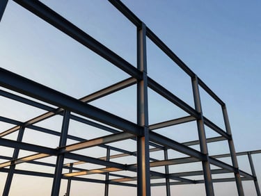 Detailed shot of structural steel framework against a clear sky, crisp morning light, high structural detail, wide-angle lens.