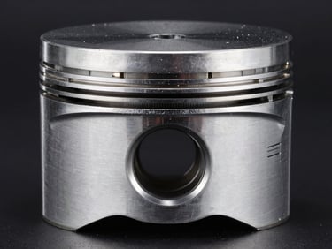 Macro studio shot of a high-performance engine piston, metallic reflections, sharp technical details, deep shadows