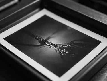 Close-up of a darkroom tray, silver halide print emerging in developer fluid, dramatic shadows, rich charcoal tones.