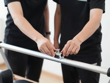 Close up of a clean-cut uniformed technician adjusting precision bearings on an aluminum Pilates reformer rail, 50mm