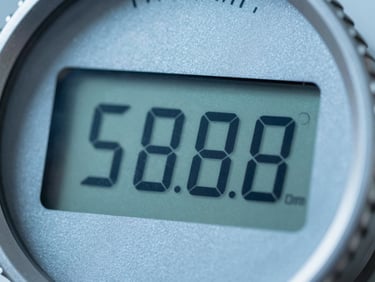 Macro close-up of a high-precision digital flow meter interface, cool steel-blue tones, sharp focus on digital readout
