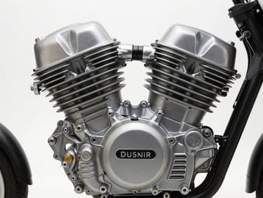 Close-up overhead shot of a two-wheeler engine block showing the cylinder head fins, engine badge, and cooling vents under neutral studio light, no rider or human elements