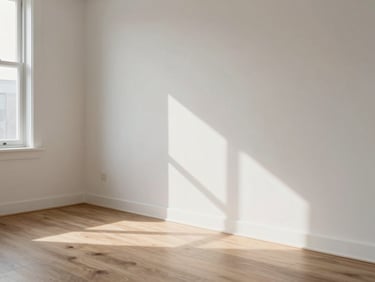 Medium shot of a freshly completed renovation — smooth painted wall meeting new laminate flooring, natural morning window light showing surface quality and paint finish, no people, close enough to assess material quality