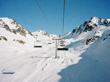 Empty chairlift ascending over frozen peaks in Ushuaia, crisp winter sun, sharp shadows on fresh powder, 35mm