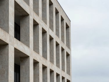 Abstract architectural detail of a modern limestone courthouse facade, sharp shadows under overcast daylight, clean geometric lines, generous negative space on the right third.