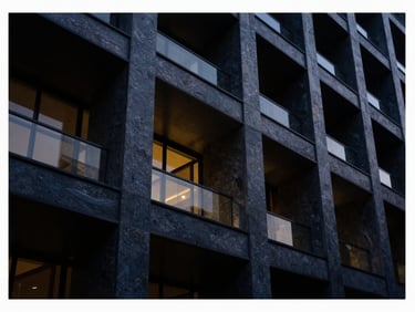 Architectural close-up of modern steel-and-stone structure, low-key lighting, deep navy tones, 35mm.