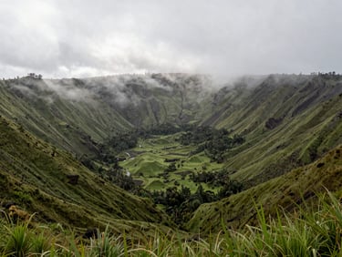 Panoramic view of El Valle de Antón volcanic crater, lush green slopes shrouded in mist, peaceful morning atmosphere