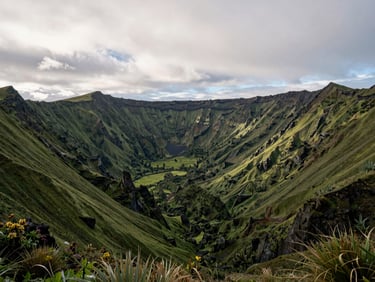 Lush volcanic crater valley of El Valle de Antón, surrounded by jagged green peaks under a soft overcast sky, cinematic landscape.