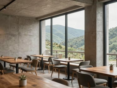 Interior of a modern luxury cafe with minimalist concrete walls, warm wooden tables, and large glass windows overlooking green hills, soft natural daylight