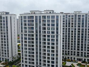 High-angle exterior view of a dense modern apartment complex, clean lines, neutral overcast daylight, emphasizing structural density.