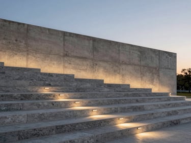 Poured-in-place concrete retaining walls integrated with wide stone steps and minimalist architectural lighting at dusk