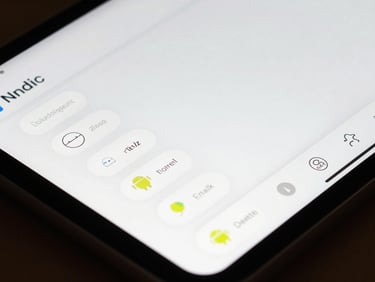 Macro close-up of a large-type Android app interface on a small tablet, bold rounded buttons visible, clean white UI on screen, overhead studio light, no hands or people