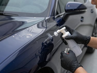 Tight shot of a professional applying a ceramic coating to a car's fender, light reflecting off the glossy surface, crisp reflections