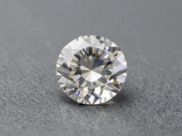Single loose diamond on a matte stone-grey surface under controlled north-facing studio light, facets rendered with precise brilliance, extreme close-up showing clarity and cut geometry, no props