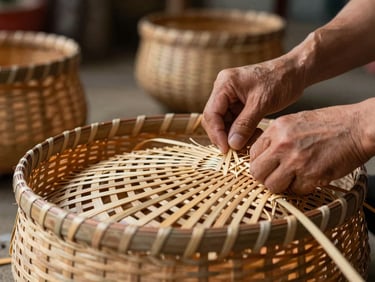 Close-up of hands weaving traditional bamboo baskets in a well-lit rural workshop.