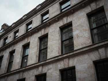 Low-angle architectural close-up of a Portland stone facade in Mayfair, sharp overcast daylight, deep shadows, desaturated tones, 35mm lens.