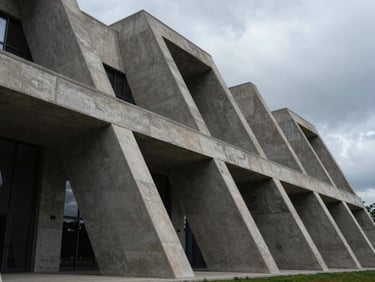Wide structured architectural shot of a modern courthouse facade, sharp concrete angles, deep shadows, overcast cool natural light.