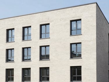 Modern multi-family brick building exterior, clean lines, bright natural daylight