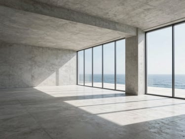 Wide sweeping environmental shot of a modern minimalist design studio with clean concrete lines, high-contrast crisp daylight, ocean views visible through large windows.