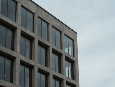Architectural detail of a modern concrete and glass office building facade in Utah, clean geometric lines, overcast daylight.