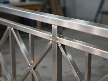 Close-up of a custom casting aluminium balcony railing, flawless welds, brushed steel textures, modern geometric pattern, sharp workshop lighting.
