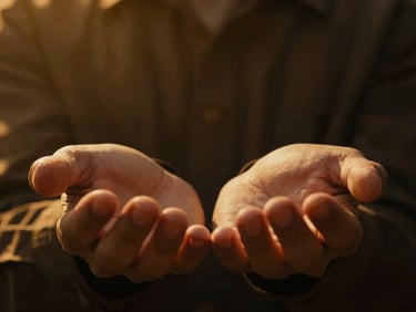Cinematic close-up of hands held open in prayer, warm golden backlighting, high contrast, shallow depth of field