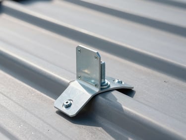Extreme close-up of a heavy-duty anodized aluminum solar mounting bracket bolted to a modern standing-seam metal roof, harsh direct midday sunlight casting sharp shadows, highlighting the metallic texture and robust engineering.