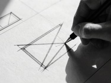 Extreme close-up of a hand sketching bold, geometric shapes on a blueprint, stark shadows, harsh studio light. High-contrast black and white photography, sharp focus, 35mm film grain.