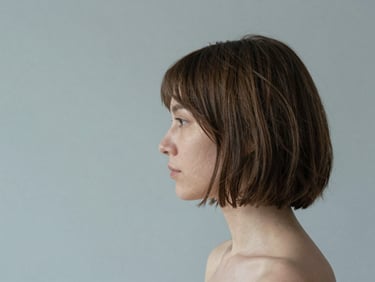 Minimalist portrait of a woman with a precise architectural bob, showing natural texture and soft shadows, 35mm
