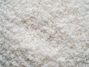 Macro texture of premium white desiccated coconut, sharp detail, clean industrial lighting, 50mm lens
