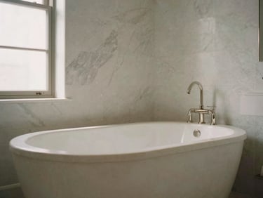 Architectural detail shot of a luxury master bathroom, freestanding stone tub, neutral marble tiling, soft diffused light.