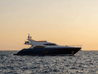 A luxury yacht sailing on quiet deep blue waters under a golden sunset sky, wide shot, elegant travel