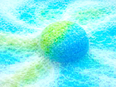 Extra large blue and green bath bomb fizzing with rich, colorful foam.