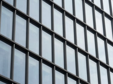 Tight macro crop of a modern steel and glass facade, repeating geometric patterns, cool diffused light