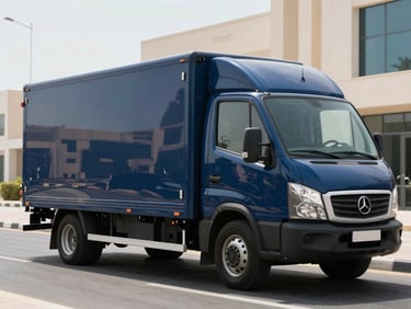 A clean, branded commercial transport vehicle parked on a modern Abu Dhabi street, bright midday desert light reflecting off its polished navy blue side panel.