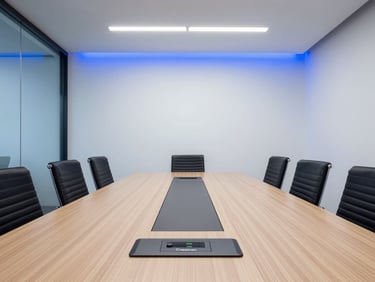 Straight-on architectural shot of a modern corporate boardroom, clean oak table with a sleek Crestron touch panel, cool clean office lighting, blue LED accents.