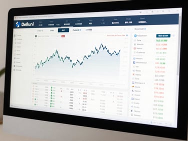 Wide close-up of a desktop monitor displaying an investment portfolio dashboard with real-time balance figures, a clean line performance chart, and a scrollable transaction history list, bright even studio lighting, no glare, procedural and readable
