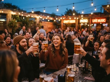 A lively crowd of people laughing and holding up beer pints on an outdoor wooden patio at dusk, warm string lights overhead, shallow depth of field, 35mm film.