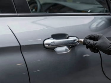 Close-up of the same metallic grey car door panel after high-precision dent pulling, computerized paint matching, and clear coat application.