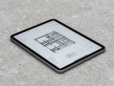 A high-end modern tablet displaying structural site logs and architectural charts, resting on a raw concrete surface, crisp focus, overcast daylight.