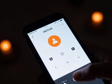 Close-up of a smartphone screen displaying a security app interface with arm and disarm controls, held in a hand inside a dark room with orange status lights, 35mm