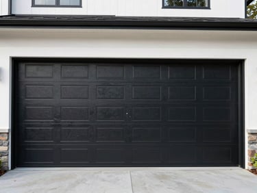 Wide shot of a newly installed modern insulated black steel garage door on a contemporary Pacific Northwest home, daytime