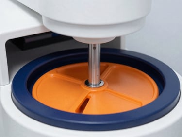 Macro detail shot of sterile, high-precision laboratory centrifuge under clean clinical white studio lighting, crisp industrial photography, high-contrast navy and safety orange tones, sharp focus, 35mm.